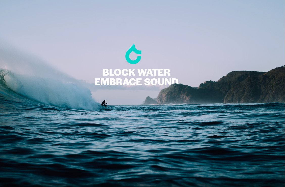 Surfer inside a wave with the SEAR motto: block water, embrace sound