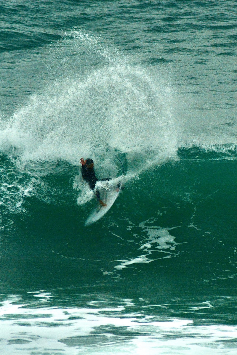 Surfer in the water wearing SEAR Plugs